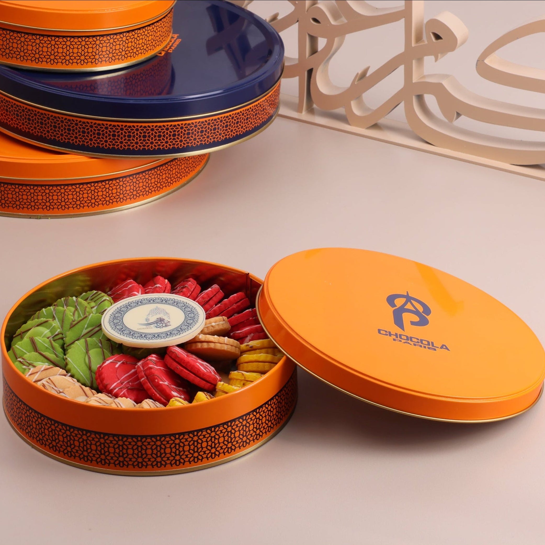 Colorful cookie tins with a decorative item on a light surface